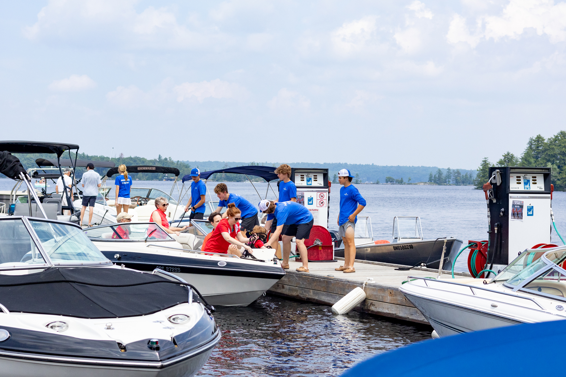 Marina crew help boaters tie up to dock and pump fuel