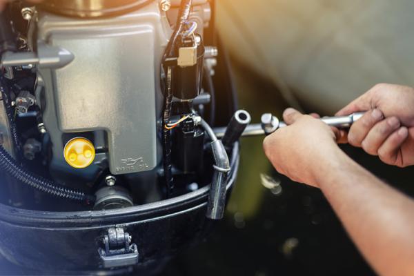 Boat Mechanic working on an outboard engine at Wye Heritage Marine Resort in Midland